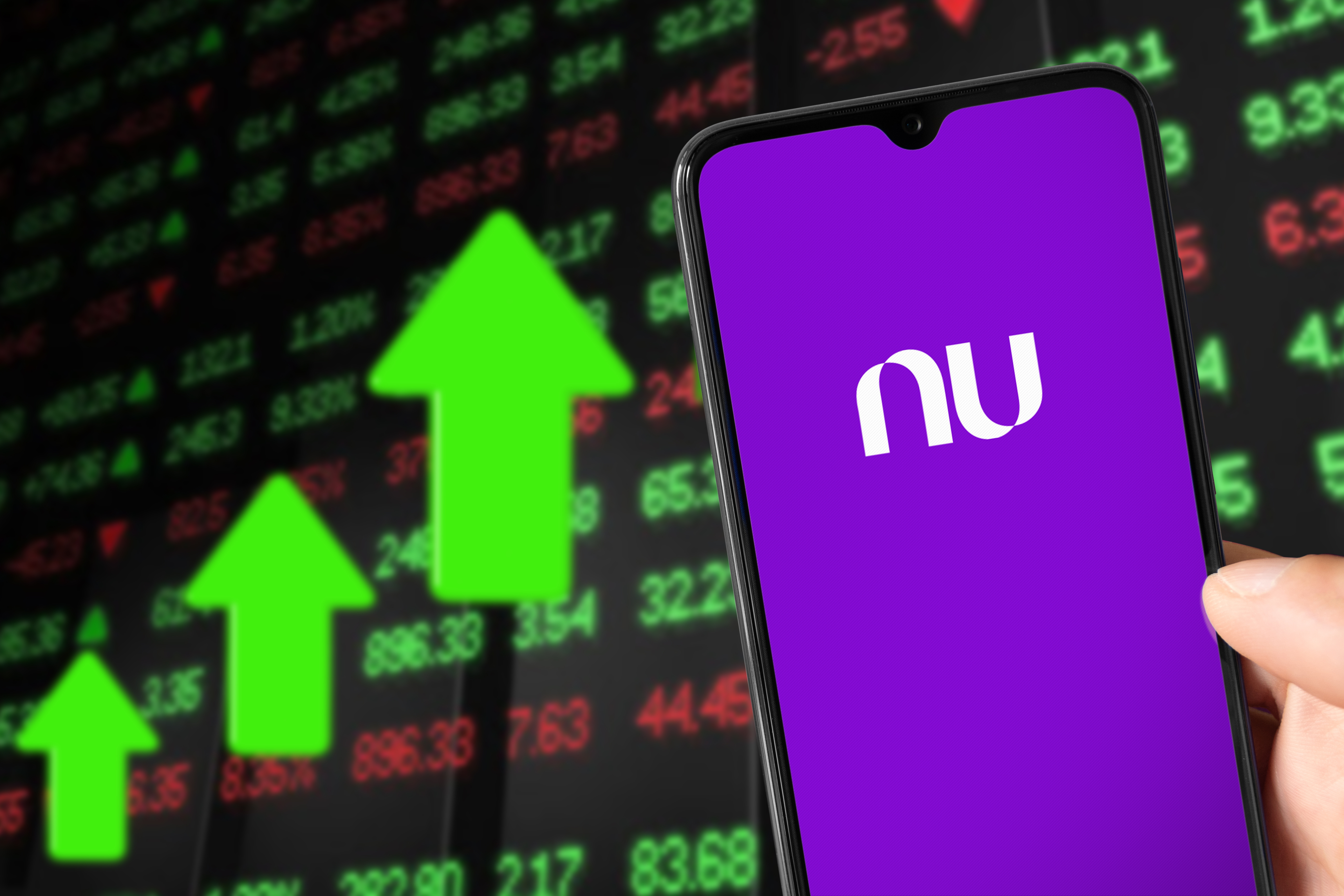 Smartphone with NuBank logo and background showing market value