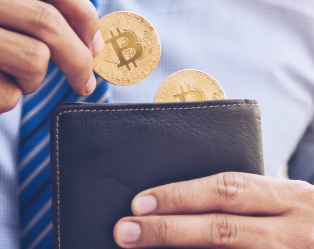 A businessman is taking a coin bit in a wallet.The concept of mo
