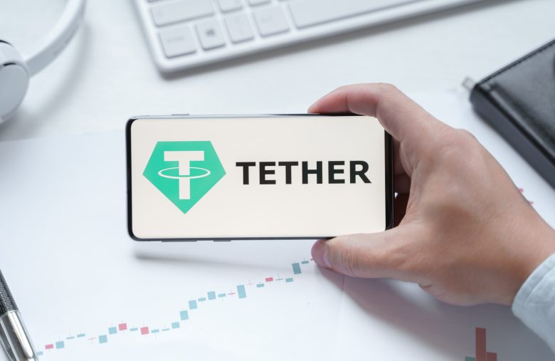 Russia Moscow 08.06.2021 Man holding logo of Tether USDT token in mobile phone. Cryptocurrency stablecoin. Cryptocurrency token USDT. Trading blockchain decentralized exchange DEX. Digital money