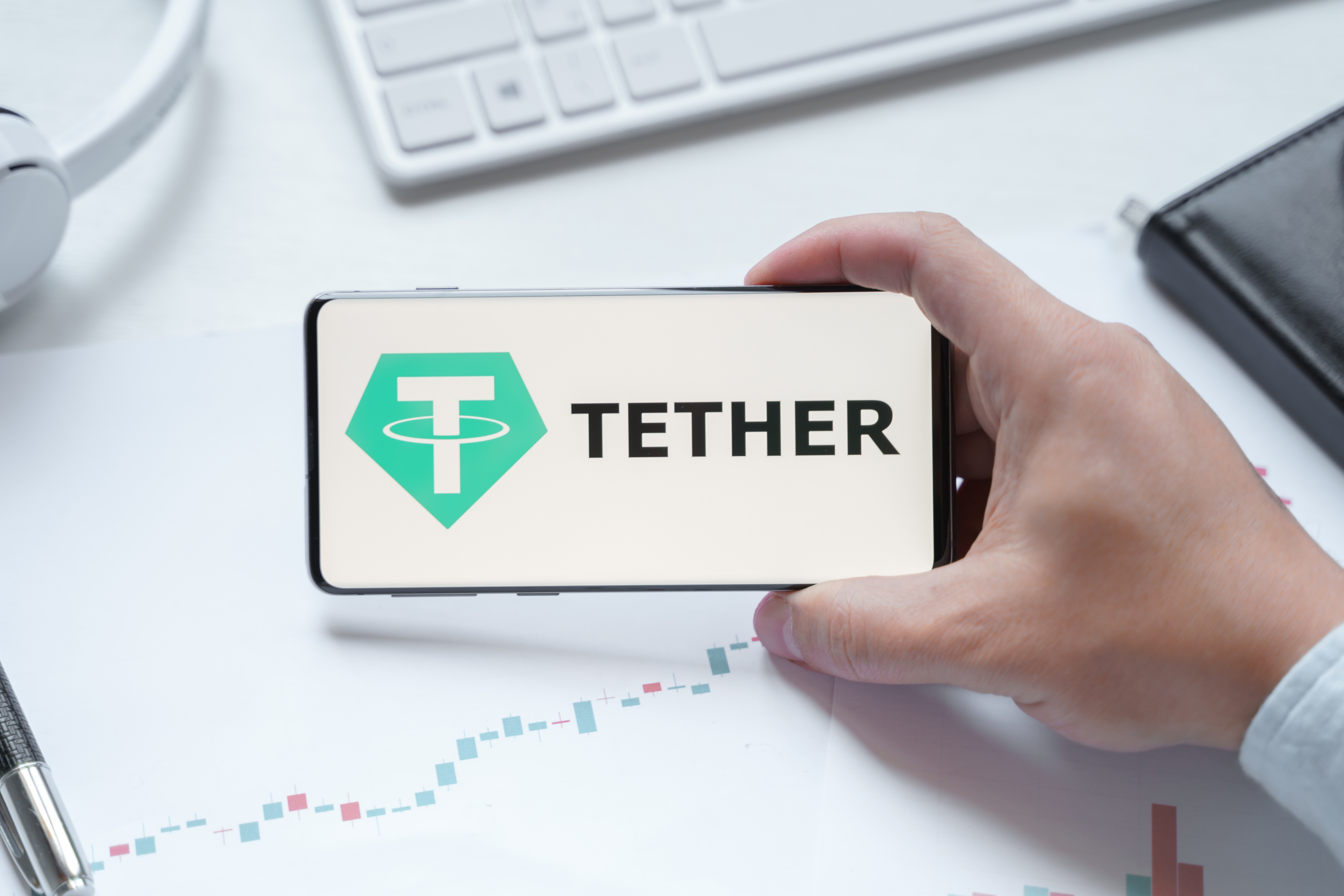 Russia Moscow 08.06.2021 Man holding logo of Tether USDT token in mobile phone. Cryptocurrency stablecoin. Cryptocurrency token USDT. Trading blockchain decentralized exchange DEX. Digital money